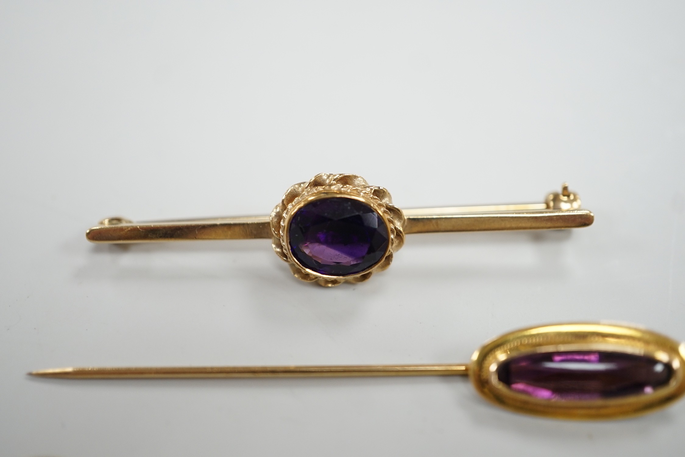 Three assorted yellow metal and gem set stick pins, including 9ct gold and diamond set horseshoe, 58mm and a modern 9ct gold and gem set bar brooch, gross weight 9.2 grams.